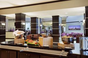 a restaurant with a buffet with bowls of food on a counter at Embassy Suites by Hilton St Louis Airport in Bridgeton