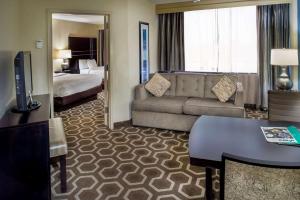 a hotel room with a couch and a bed at Embassy Suites by Hilton St Louis Airport in Bridgeton