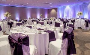 un salón de banquetes con mesas blancas y sillas con arcos en DoubleTree by Hilton St. Louis at Westport, en Maryland Heights