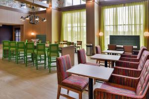 Hampton Inn & Suites Saint Paul Oakdale Woodbury في وودبري: مطعم بطاولات وكراسي ودروس