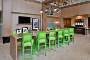 a dining room with a table and green chairs at Hampton Inn & Suites Saint Paul Oakdale Woodbury in Woodbury