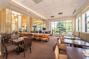 a restaurant with tables and chairs and windows at Hilton Garden Inn Fishkill in Fishkill