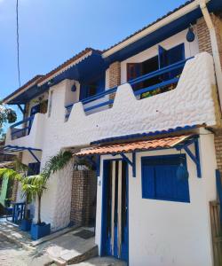 Biały dom z niebieskimi drzwiami i palmą w obiekcie Ganesha Hostel w mieście Pipa