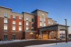 um grande edifício de tijolos com uma torre de relógio no topo em Homewood Suites by Hilton Syracuse - Carrier Circle em East Syracuse