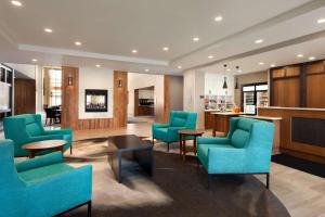 a waiting room with blue chairs and a table at Homewood Suites by Hilton Syracuse - Carrier Circle in East Syracuse
