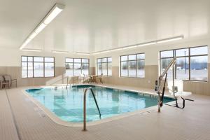 a large swimming pool in a large room with windows at Homewood Suites by Hilton Syracuse - Carrier Circle in East Syracuse