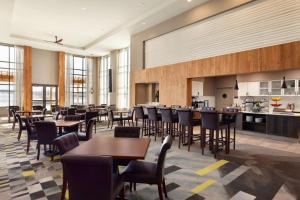 um restaurante com mesas e cadeiras e uma cozinha em Homewood Suites by Hilton Syracuse - Carrier Circle em East Syracuse