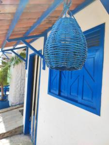 niebieskie drzwi i kosz wiszący z domu w obiekcie Ganesha Hostel w mieście Pipa