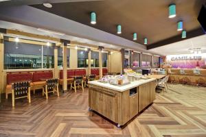 um restaurante com um bar e mesas e cadeiras em Tru By Hilton Syracuse-Camillus em Camillus