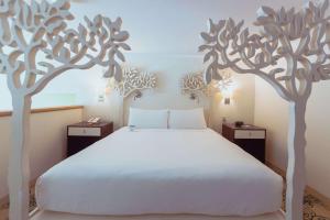 a bedroom with a white bed with trees on the wall at Hotel Skyler Syracuse, Tapestry Collection by Hilton in Syracuse