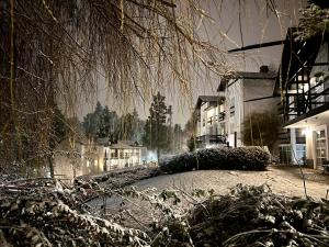 una calle nevada por la noche con edificios y árboles en Aldea Andina Hotel&Spa en San Carlos de Bariloche