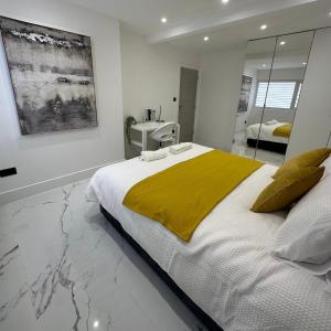 a bedroom with a large bed with a yellow blanket at Entire home in Nottingham in Nottingham