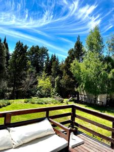 1 cama en una terraza de madera con cielo azul en Aldea Andina Hotel&Spa en San Carlos de Bariloche