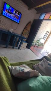 salon z telewizorem, kanapą i telewizorem w obiekcie Ganesha Hostel w mieście Pipa