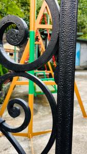 una recinzione in ferro battuto nero con un parco giochi sullo sfondo di Dato's GuestHouse a Makhinjauri
