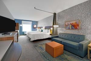 pokój hotelowy z łóżkiem i kanapą w obiekcie Home2 Suites By Hilton Utica, Ny w mieście Utica