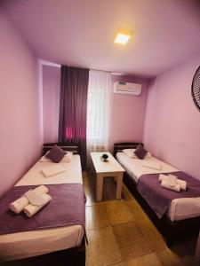 2 camas en una habitación con paredes moradas en MarNar Hotel en Ereván