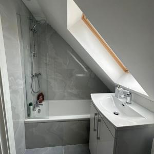 y baño blanco con lavabo y ducha. en Entire home in Nottingham en Nottingham