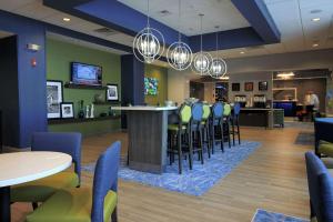 a bar in a waiting room with chairs and tables at Hampton Inn West Plains in West Plains