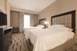 a hotel room with two beds and a television at Embassy Suites by Hilton Tuscaloosa Alabama Downtown in Tuscaloosa +32 photos