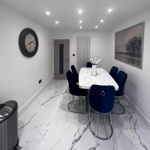 comedor con mesa, sillas y reloj en Entire home in Nottingham en Nottingham