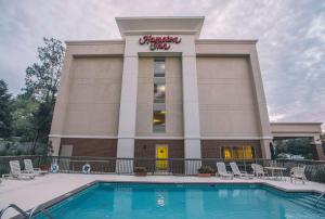 a hotel with a swimming pool in front of a building at Hampton Inn Tallahassee-Central in Tallahassee