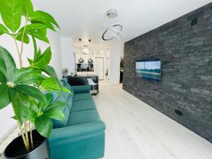 a living room with a blue couch and a brick wall at Aici te simți ca acasa 2 in Iaşi