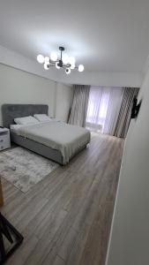 um quarto com uma cama e piso em madeira em Аэропорт Апартаменты 24&24 em Chisinau