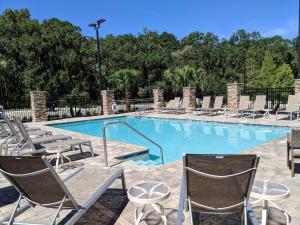 a large swimming pool with chairs and a table at Hilton Garden Inn Tampa - Wesley Chapel in Wesley Chapel