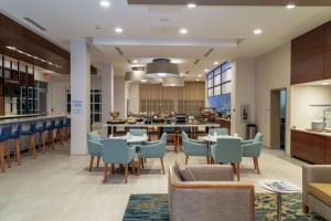 a restaurant with tables and chairs and a bar at Hilton Garden Inn Tampa - Wesley Chapel in Wesley Chapel