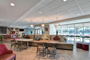 a lobby with a couch and tables and chairs at Home2 Suites By Hilton Tampa USF Near Busch Gardens in Tampa