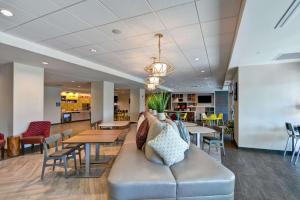a lobby with a couch and tables and chairs at Home2 Suites By Hilton Tampa USF Near Busch Gardens in Tampa