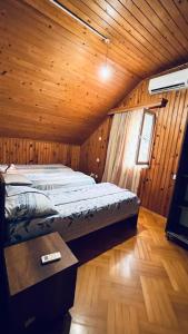 una camera da letto con letto in una camera in legno di Dato's GuestHouse a Makhinjauri