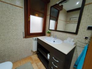 uma casa de banho com um lavatório e um espelho em Casa em Artea