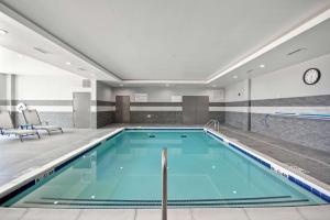 a swimming pool in a hotel room with a swimming pool at Hilton Garden Inn Tulsa-Broken Arrow, OK in Broken Arrow