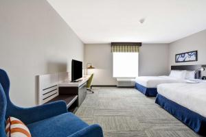 a hotel room with two beds and a tv at Hilton Garden Inn Tulsa-Broken Arrow, OK in Broken Arrow