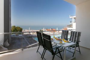 einen Balkon mit einem Tisch und Stühlen sowie Meerblick in der Unterkunft Oceanview Dreamer's Delight in Nazaré