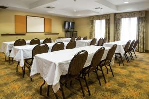 una sala de conferencias con mesas, sillas y una pantalla en Hampton Inn Tulsa/Broken Arrow en Broken Arrow