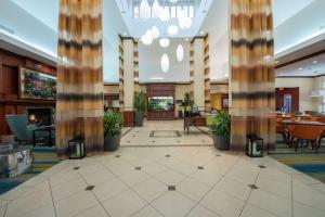 a large lobby with tables and chairs and columns at Hilton Garden Inn Tupelo in Tupelo