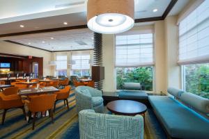 un comedor con mesas, sillas y ventanas en Hilton Garden Inn Tupelo en Tupelo