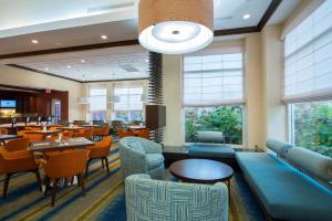 a dining room with tables and chairs and windows at Hilton Garden Inn Tupelo in Tupelo