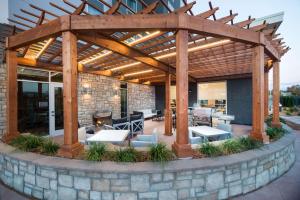 an outdoor patio with a wooden pergola at Homewood Suites By Hilton Tulsa Catoosa in Catoosa