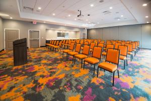 una sala de conferencias con sillas naranjas y un podio en Homewood Suites By Hilton Tulsa Catoosa en Catoosa
