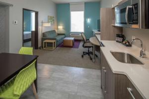 OwassoHome2 Suites by Hilton Owasso的带水槽的厨房和客厅