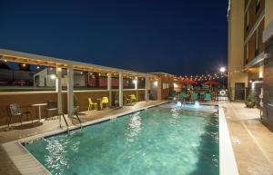 a swimming pool in a hotel at night at Home2 Suites by Hilton Owasso in Owasso