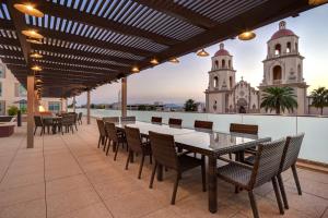 eine Terrasse mit einem Tisch und Stühlen sowie ein Gebäude in der Unterkunft Home2 Suites By Hilton Tucson Downtown in Tucson