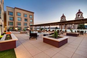 um pátio com mesas e cadeiras e um edifício em Home2 Suites By Hilton Tucson Downtown em Tucson