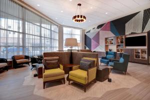 a waiting room with furniture and a tv and windows at Home2 Suites By Hilton Tucson Downtown in Tucson