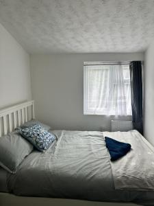 a bed with two pillows on it in a bedroom at Charming Four Bedroom Holiday Home in Harlow