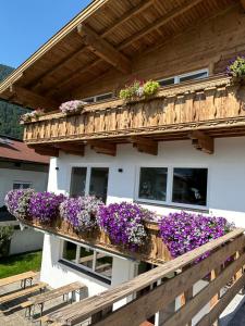 ein Gebäude mit vielen Blumen auf dem Balkon in der Unterkunft Gruppenhaus Alpenglück in Kirchdorf in Tirol